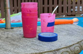 pink glasses on a table with blue tape