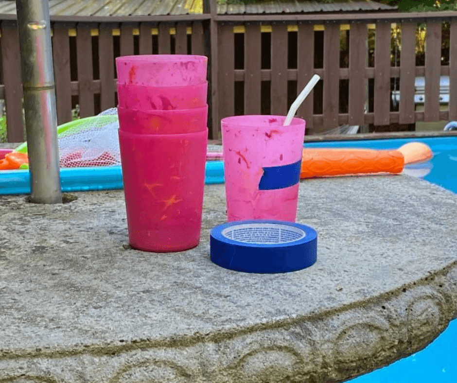 pink glasses on a table with blue tape