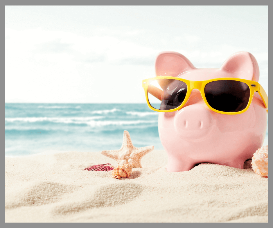 A piggy bank wearing sunglasses on a beach