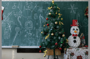 A Christmas Tree and Snowman setting on a teacher's desk.