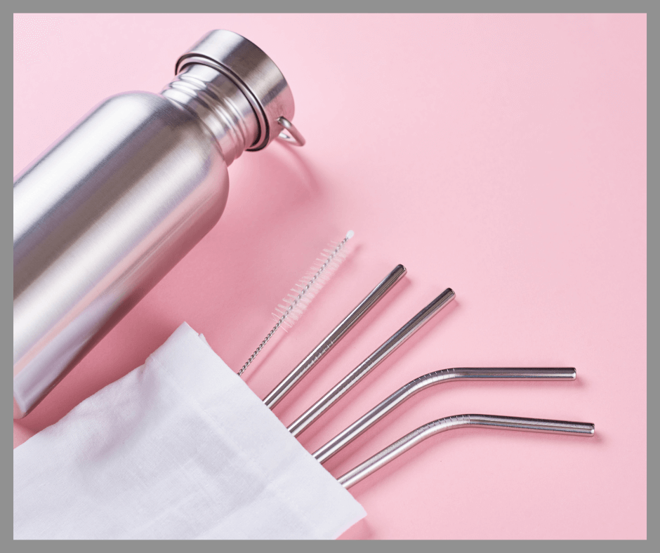 Reusable straws in a pouch with a bottle on a pink background