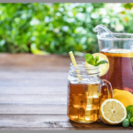 Iced tea with lemons in a glass and pitcher