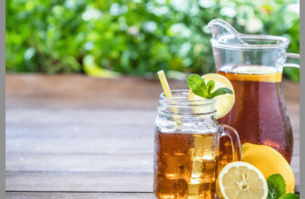 Iced tea with lemons in a glass and pitcher