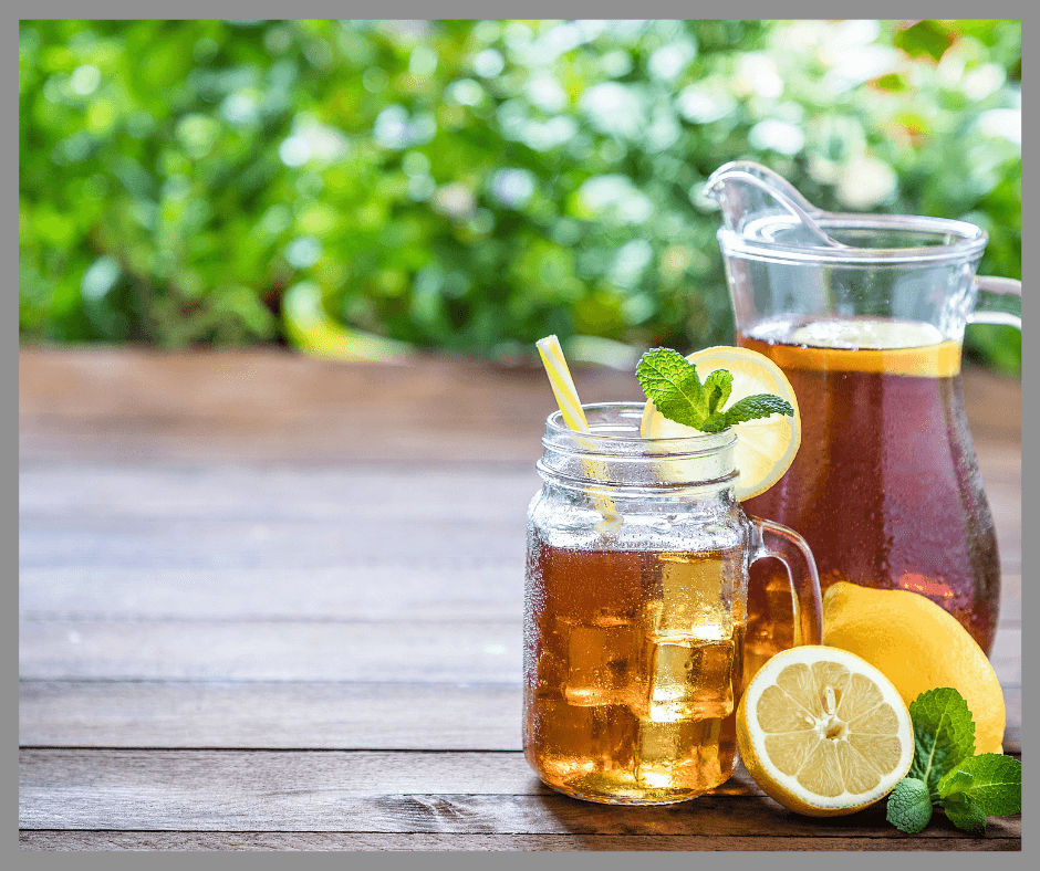 Iced tea with lemons in a glass and pitcher