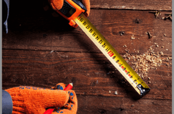 A carpenter using a yellow tape measure