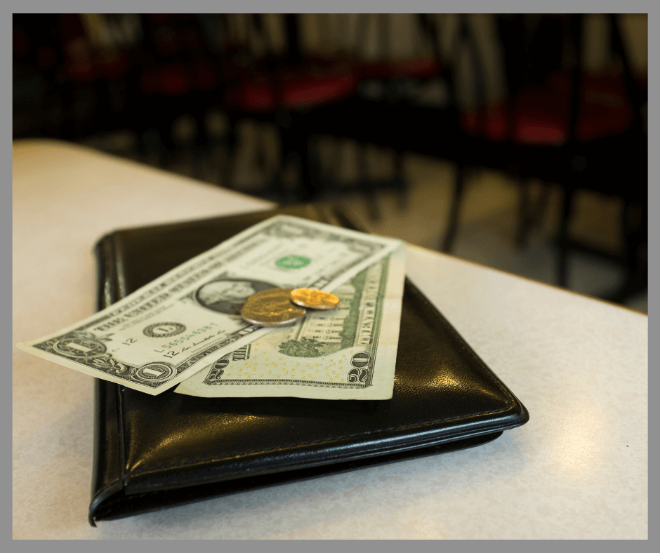 Dollar bills on top of a restaurant folder