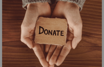 Two hands holding a donate sign