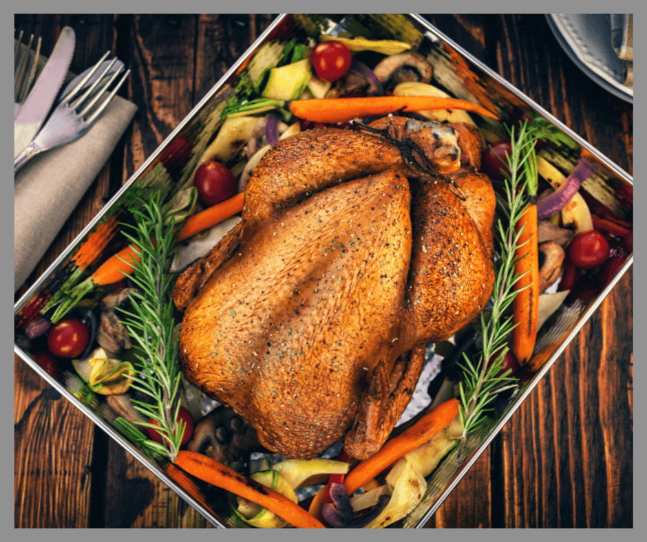 A Roasted Turkey in a pan of vegetables
