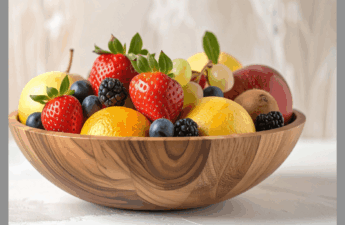 A wooden bowl full of fresh fruits and vegetables